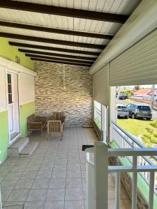un porche de una casa con patio en Jolie maison saisonnière en Guadeloupe de 160m2 disposant de 4 chambres 2 toilettes une grande véranda et terrasse, en Vieux-Fort