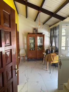 a room with a table and a wooden door at Jolie maison saisonnière en Guadeloupe de 160m2 disposant de 4 chambres 2 toilettes une grande véranda et terrasse in Vieux-Fort