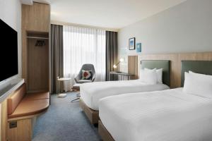 una camera d'albergo con due letti e una televisione di Courtyard by Marriott Zurich North a Zurigo