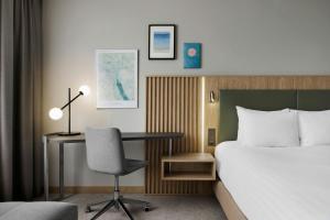 una camera d'albergo con letto e scrivania con sedia di Courtyard by Marriott Zurich North a Zurigo