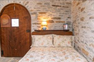 a bedroom with a bed and a wooden door at Πέτρινο in Tinos