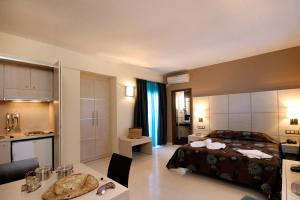 a bedroom with a bed and a kitchen and a bathroom at Theros Hotel in Tavronitis