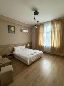 a bedroom with a bed and a large window at Hotel Tatul in Momchilgrad