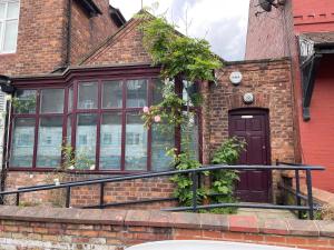 a brick house with a purple door and windows at Quirky house in Manchester