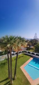 two palm trees next to a swimming pool at Penthouse S.Jorge Seaview T4 in Quarteira