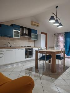 a kitchen with a wooden table and blue cabinets at Belo Horizonte Loft in Montesilvano