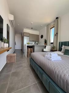 a bedroom with a large bed and a kitchen at Stay and Chill -Luxury Studio in Kato Paphos in Paphos City
