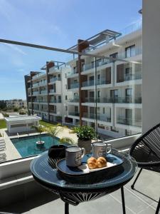 a table with a tray of donuts on a balcony at Stay and Chill -Luxury Studio in Kato Paphos in Paphos City