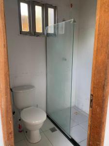 a bathroom with a toilet and a glass shower at Chácara Pedacinho do Duro - Matapuã in Aracaju +7 photos