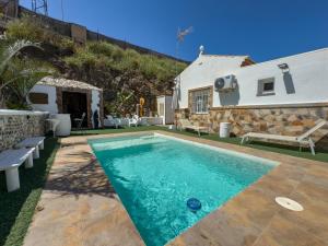 a villa with a swimming pool in front of a house at Villa Tarifa in Torrox