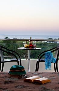 a table with a book and a bottle on a table at Theros Hotel in Tavronitis