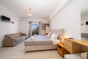 a bedroom with a bed and a couch at Dimitris Studios in Karavomylos
