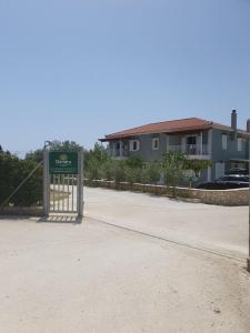 a gate with a sign in front of a building at Dendra Apartments at Skala in Poros +42 photos