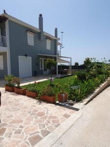 a house with plants and flowers in front of it at Dendra Apartments at Skala in Poros