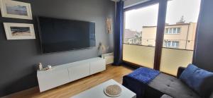 a living room with a flat screen tv on a wall at ApartMorze Apartamenty na Leśnej in Jastarnia