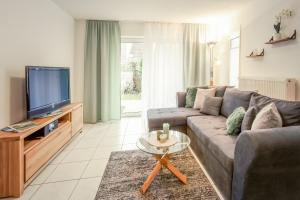 a living room with a couch and a tv at Fewo Sonnenblick in Gaienhofen +5 photos
