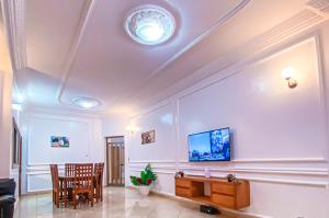 a living room with a table and a tv on the ceiling at KLEIN Résidence de FAFA in Abomey-Calavi