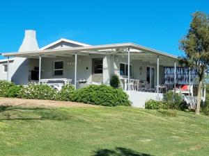 a white house with a lawn in front of it at Rose Cottage AtTheDairyShed in Heidelberg
