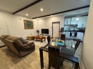 a living room with a glass table and a couch at Sable Suites B1, 1 Bed Apartments in Kabulonga in Lusaka