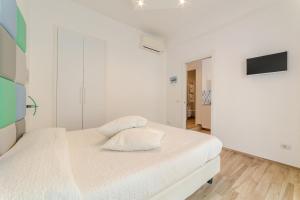 a white bedroom with a bed with a pillow at MiniSuites iCostaioli in Maiori