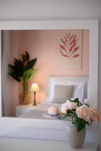 a bedroom with a bed and a vase of flowers at Horizon, Coastal Penthouse in Agios Nikolaos
