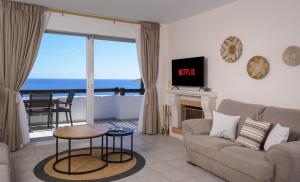 a living room with a couch and a view of the ocean at Horizon, Coastal Penthouse in Agios Nikolaos +14 photos