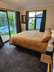una camera da letto con un letto e una grande finestra di The kiwi batch a Oban