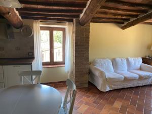 a living room with a white couch and a table at Rosa di Maggio in Pari