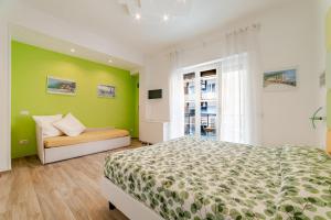 a bedroom with green walls and a bed and a window at MiniSuites iCostaioli in Maiori