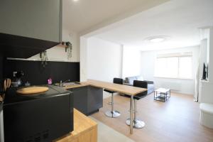 a kitchen with a counter and a table in a room at Chez Malau - Studio Neuf très cosy - Centre Ville - Parking juste en face - Proche gare - Internet - Très cosy - Canapé convertible vrai lit - Géré par Presta'Zen-Services in Verdun-sur-Meuse