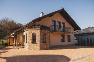 a house with a balcony on top of it at Dom v stráni in Poniky