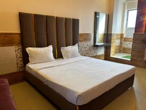 a large bed with a large headboard in a bedroom at Hotels7Apple in Mahoba +6 photos