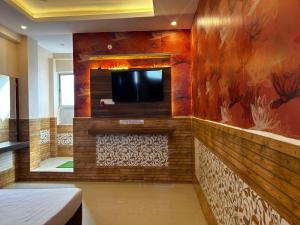 a room with a flat screen tv on a wall at Hotels7Apple in Mahoba