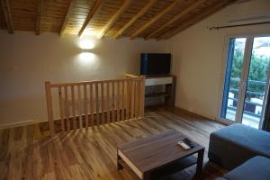 a living room with a couch and a tv at Casa Mamã e Papá in Mosteiros