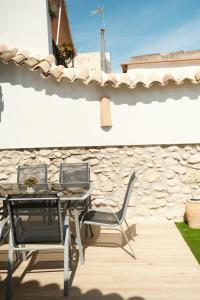 a table and chairs on a patio with a stone wall at Casa La formidable in Otos