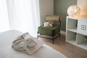 a bedroom with a bed with a chair and a towel at Bardolino Suite in Bardolino