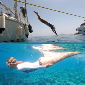 a woman laying on the side of a boat in the water at 2-cottage yacht with 2 showers in Datca