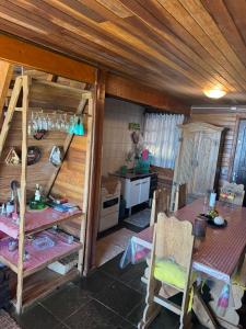 - une cuisine et une salle à manger avec une table dans une maison dans l'établissement Mirante 45 - O Chalé mais alto do Brasil, localizado a 24km de Campos do Jordão, à Santo Antônio do Pinhal