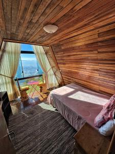 une chambre avec un lit dans une pièce en bois dans l'établissement Mirante 45 - O Chalé mais alto do Brasil, localizado a 24km de Campos do Jordão, à Santo Antônio do Pinhal