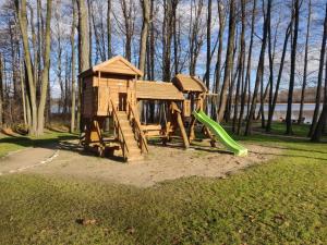 a wooden playground with a slide in a park at Stone house in Prapuntai