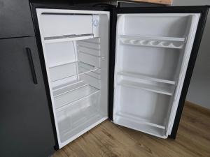 MrowinoにあるCOBBY noclegi Mrowinoの部屋の中にドアが開いたままの空の冷蔵庫