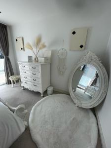 - une chambre avec un miroir et une commode blanche dans l'établissement Charming & Cosy Double Room with Balcony in Wembley - Walking Distance to Wembley Stadium!, à Londres