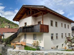 a white house with a wooden roof at Farm apartment in Stelvio National Park in Prato allo Stelvio