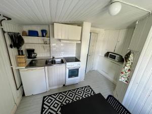 a small kitchen with white cabinets and a stove at Mitt i Borgholm in Borgholm