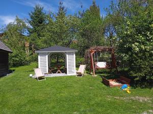 a backyard with a gazebo and chairs and a playground at Domek Mordarka in Limanowa