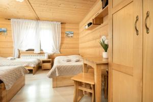 a room with two beds and a table with flowers at Willa Emilia in Zakopane