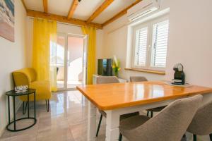 a dining room with a wooden table and chairs at Apartment Spirit of the Sea in Pašman +18 photos