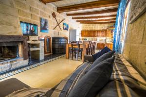 een woonkamer met een bank en een open haard bij Caqsi Farmhouse in Kerċem