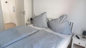 Una cama blanca con dos almohadas encima. en Ferienhaus Andy Kellenhusen - 6 Personen 3 Schlafzimmer 4, en Kellenhusen 21 fotos más