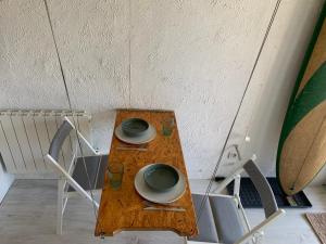 a wooden table with two plates and bowls on it at Appartement 300m de la plage in Seignosse